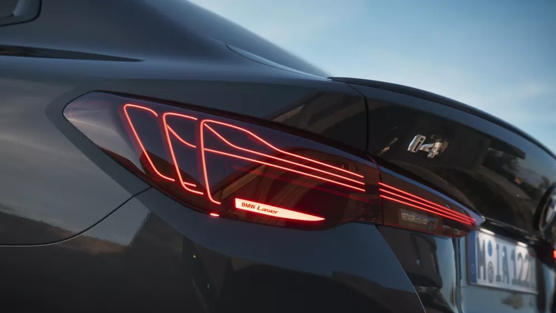 Vue arrière de la BMW i4 sur route, feux LED allumés